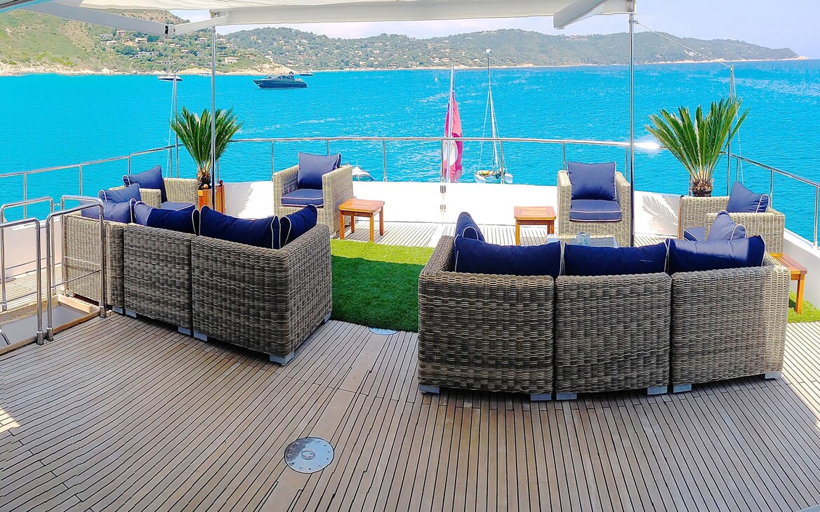 Motor yacht MIRAGGIO aerial shot of top deck with wicker seating and parasoli