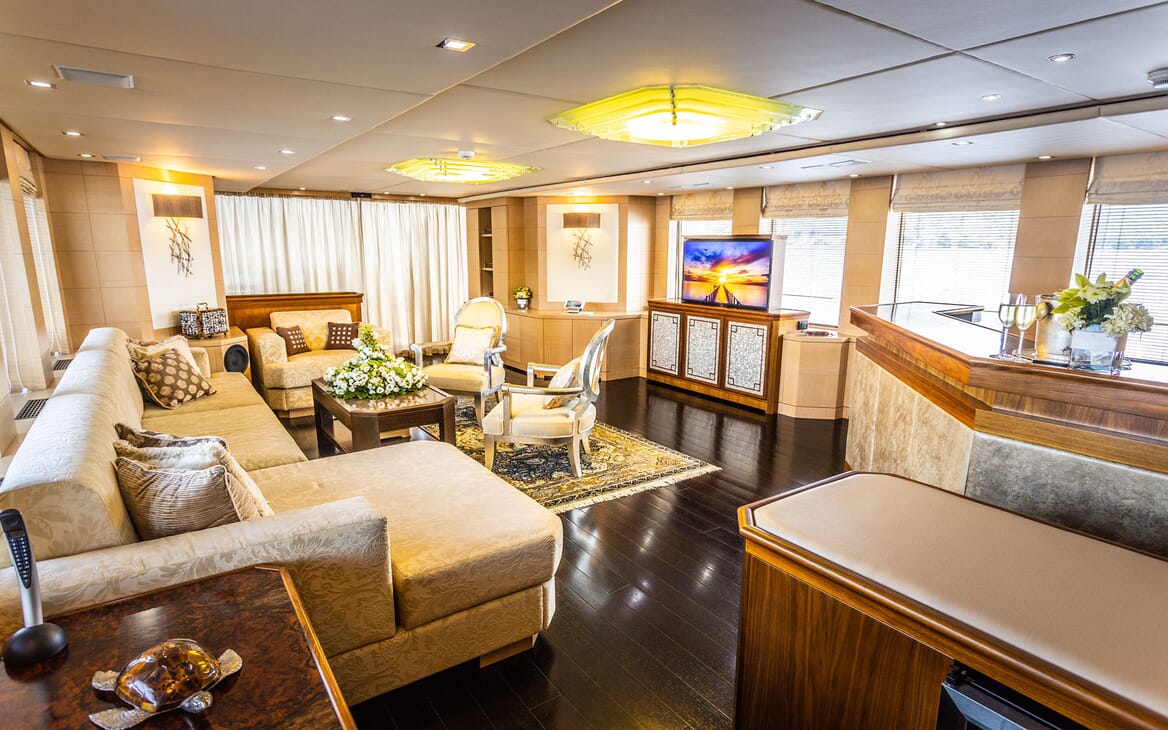 Motor yacht Milaya living room with dark wood flooring and gold and silver furnishings