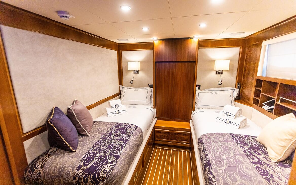 Motor yacht Milaya twin stateroom with white and purple bed linen