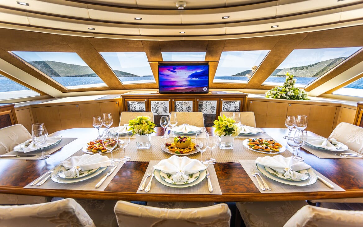 Motor yacht Milaya dining room with large table with plasma TV and seaviews