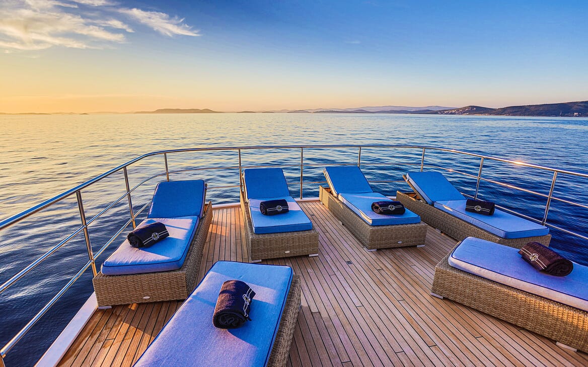 Motor yacht Milaya deck with blue sunloungers and seaviews
