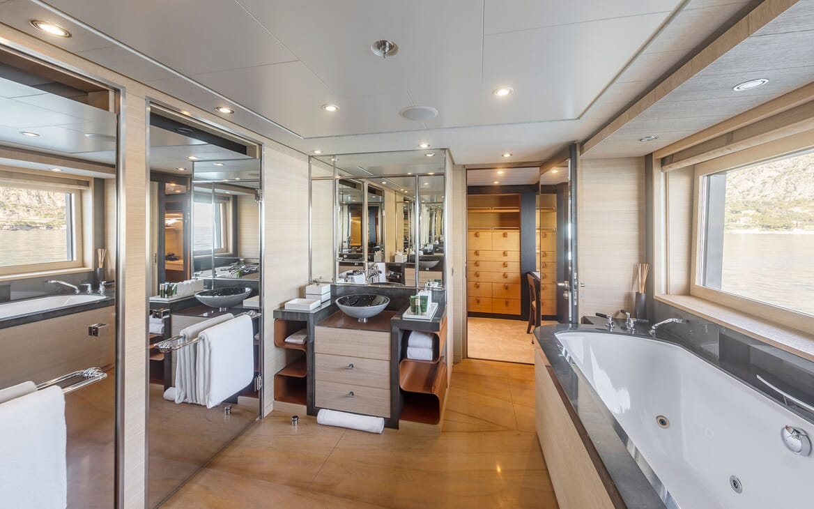 Motor yacht Spirit stateroom ensuie with jacuzzi bath tub, sink with large mirror and walk in wardrobe