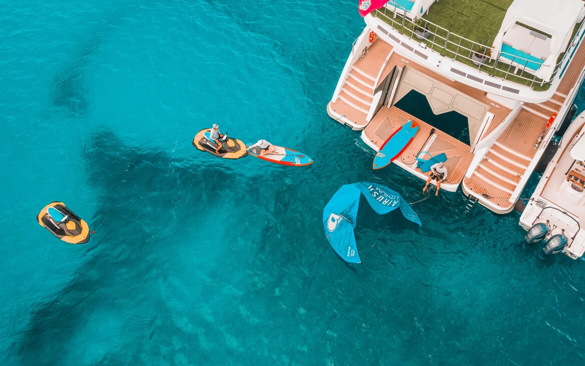 Motor yacht SAMARA aerial shot of beach club, jet skis and paddle boards on turquoise wate