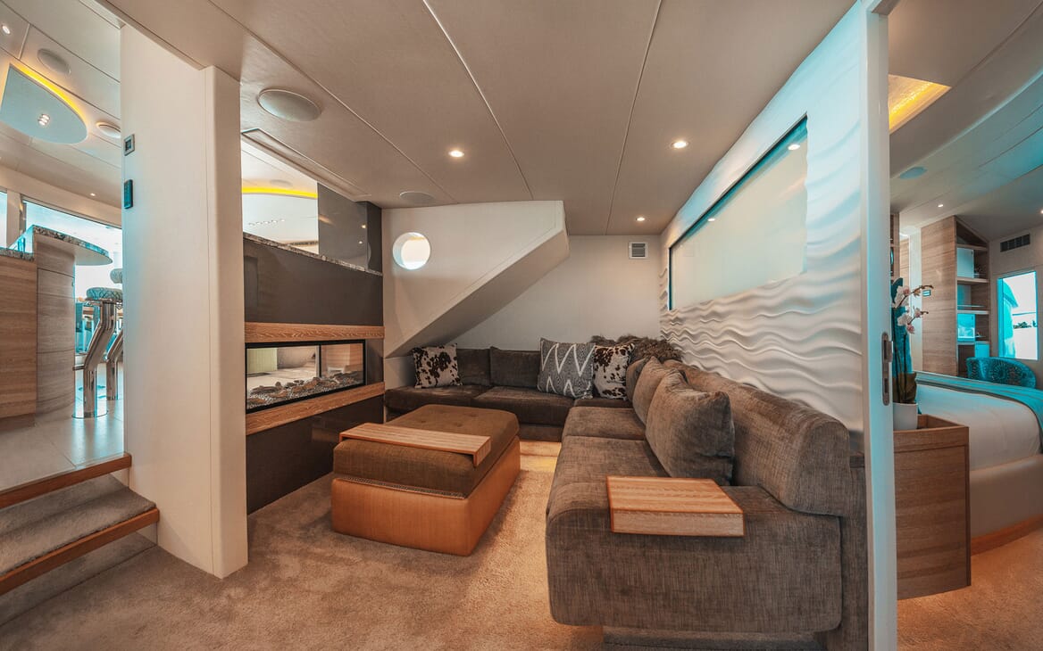Motor yacht SAMARA break out area with fish tank and L shaped brown sofa with sofa furnishings