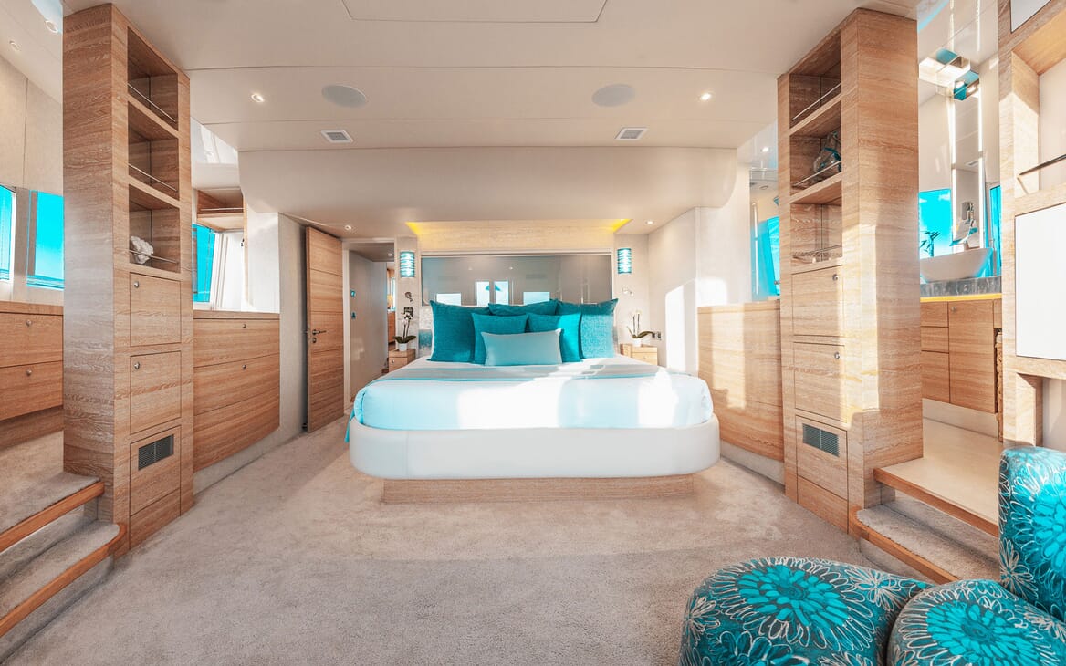 Motor yacht SAMARA master suite with white bed linen and turquoise soft furnishings, view of ensuite