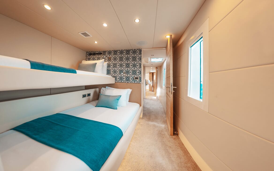 Motor yacht SAMARA twin bedroom, with bunk beds, soft cream carpet throughout, white linen with turquoise details