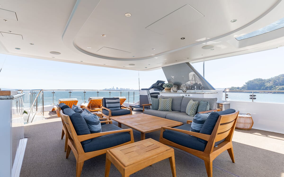 Outdoor seating area on the 39.62m yacht FIGARO. The image shows a comfortable seating arrangement on the deck, overlooking the sea.