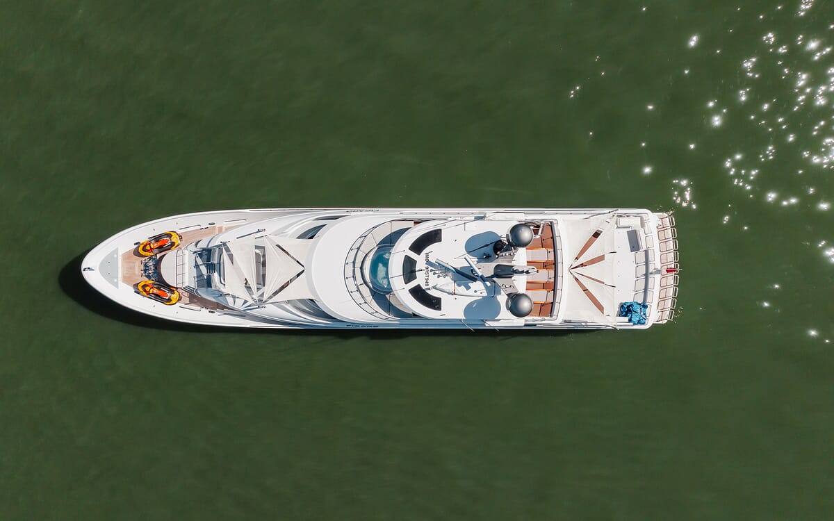 Aerial view of the 39.62m yacht FIGARO at sea. Features include a spacious deck with two jet skis, sunshades, and multiple relaxation areas.