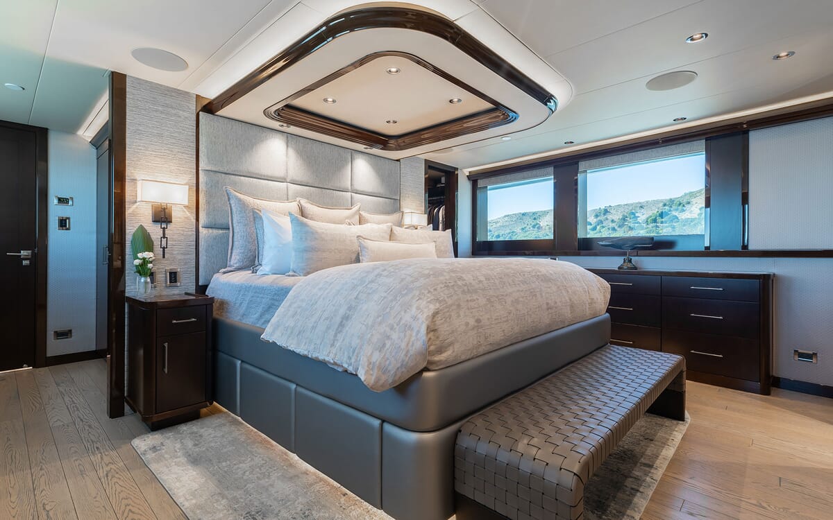Luxurious master bedroom interior aboard the 39.62m yacht FIGARO. Features include a large bed, stylish ceiling design, and large windows with a scenic view.
