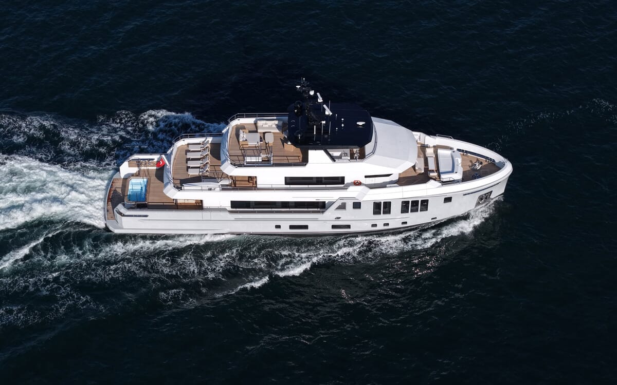 Vista aérea del BEE YACHT, un yate de 35,42 m, navegando en mar abierto. Muestra el exterior, incluida la cubierta y una pequeña piscina, desde una perspectiva lateral.