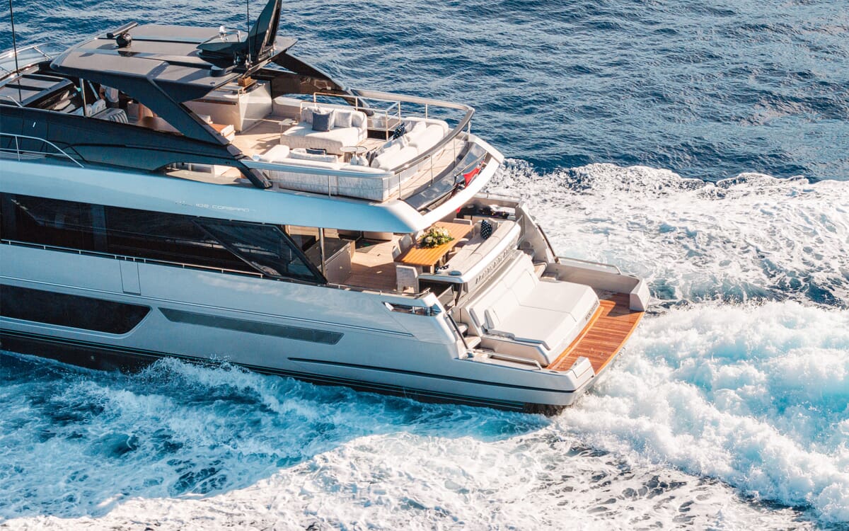 Luftaufnahme der Yacht LEMON NOT LIME, ein 30,25 m langes Schiff, auf See. Zeigt das Äußere mit Sitzgelegenheiten, einem Esstisch und dem Kielwasser im Wasser.