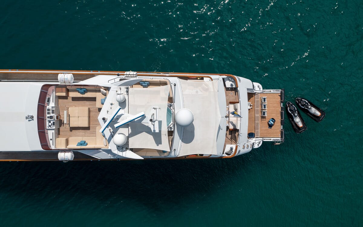 Luftaufnahme der Yacht LADYSHIP, 41,04 m lang, auf See. Zeigt das Deck mit Sonnenliegen, Radargeräten und Jetskis.