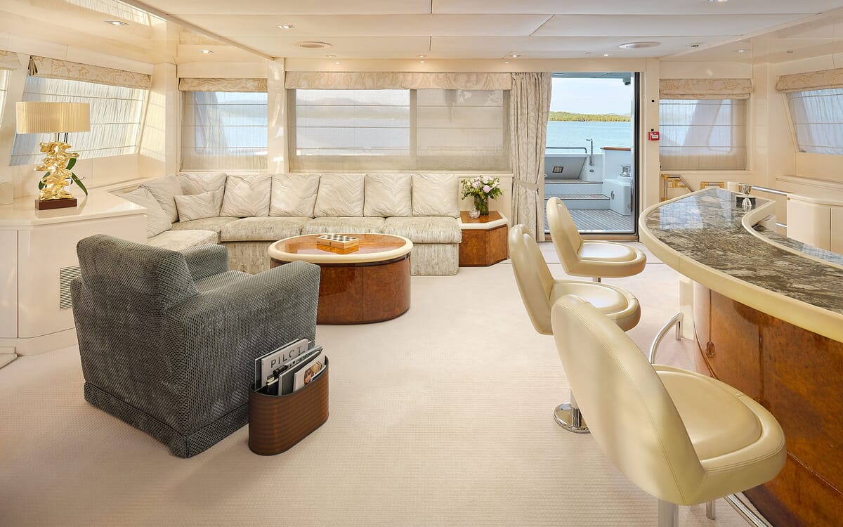 Innenansicht der Yacht LADYSHIP, ein 41,04 m langes Schiff. Das Bild zeigt einen luxuriösen Lounge-Bereich mit einer Bar, Sitzgelegenheiten und Blick auf das Meer.