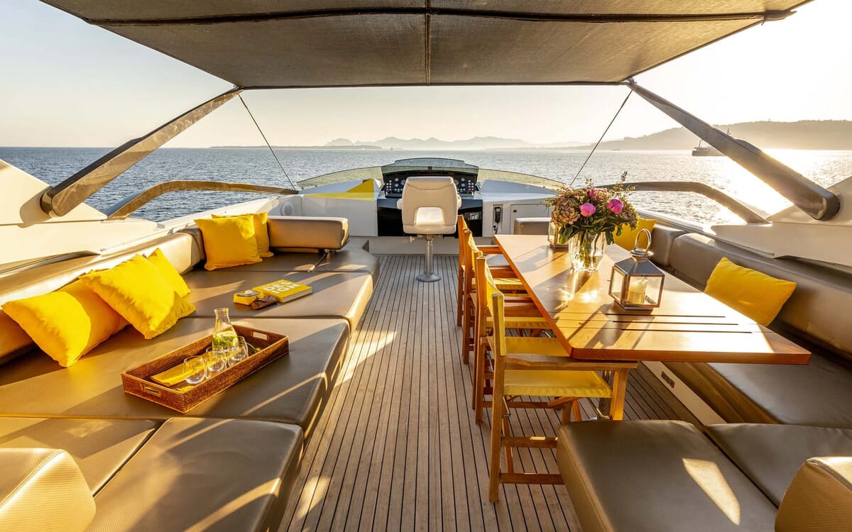 Innenansicht der QUANTUM-Yacht mit Sitzgelegenheiten, Essbereich und Steuerstand. Die 28.41m Yacht ist auf See mit sonnigem Blick.