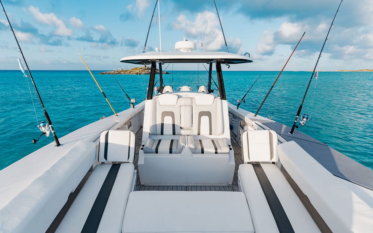 Die ODYSSEA-Yacht, ein 46,71 m langes Schiff, ist vom Heck aus gesehen, wobei die Angelruten nach außen ragen. Das Bild wurde von der Yacht auf See aus aufgenommen.