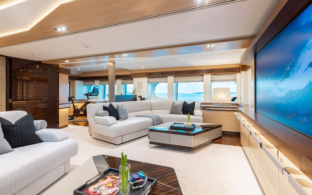 Innenansicht der ODYSSEA Yacht, mit einem luxuriösen Wohnzimmer mit bequemen Sitzgelegenheiten, großen Fenstern und einem modernen Design.